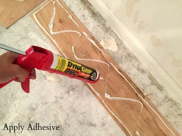 Apply adhesive to the back of the shiplap board | Install Shiplap Over Popcorn Ceiling